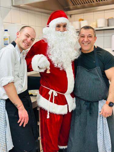 a man dressed as santa claus standing in a kitchen at Auberge Le Meisenberg in Châtenois