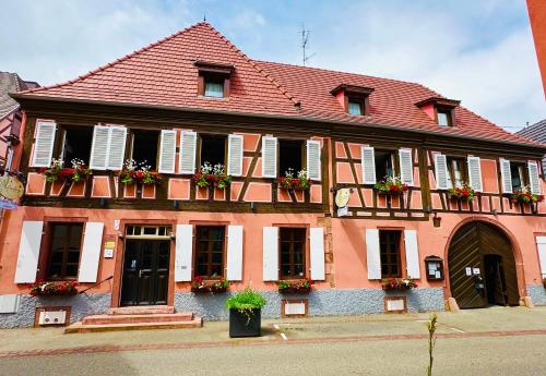 a large building with flower boxes on the windows at Auberge Le Meisenberg in Châtenois