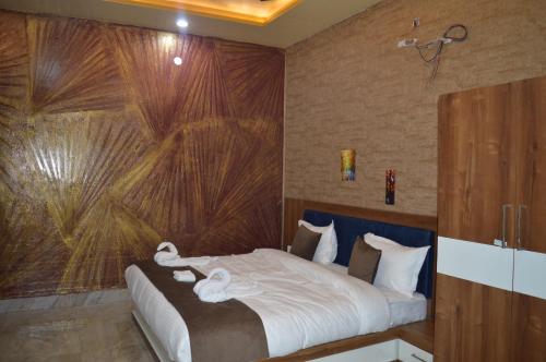 a bedroom with a bed with a large painting on the wall at Hotel AshokA in Etah