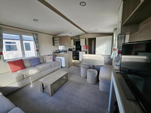a living room with a couch and a table at KMH Caravans at Flamingo Land in Kirby Misperton