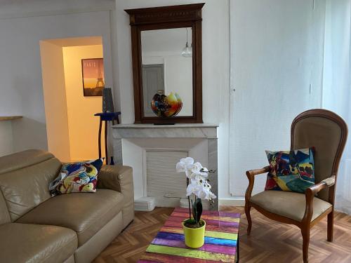 a living room with a couch and a chair and a mirror at Chez Lisoune Gite de charme sur terrasse et cour in Laragne