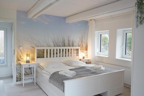 a white bedroom with a large white bed with white pillows at Entspannt Urlauben am Wasser Ferienhaus "Schuppen 23" für bis zu vier Personen! in Borgwedel