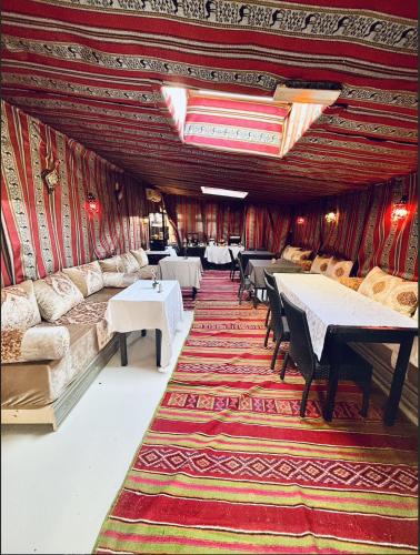 une chambre avec des tables, des canapés et un tapis dans l'établissement Hôtel Le Chalet, à Valras-Plage