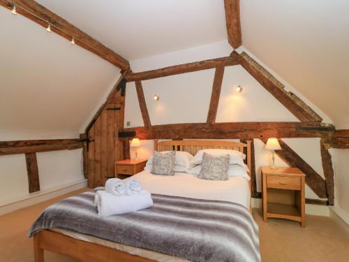 ein Schlafzimmer mit einem Bett und zwei Handtüchern in der Unterkunft April Cottage in Chipping Campden