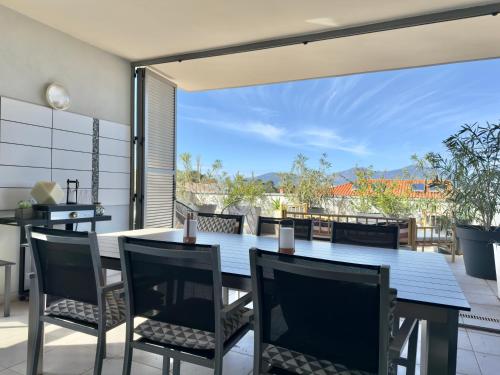une salle à manger avec une table et des chaises sur un patio dans l'établissement Rare grand appartement standing terrasse et jardin - Porticcio proche mer, à Porticcio
