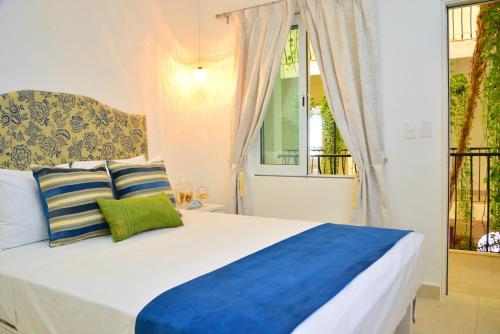 a bedroom with a bed with blue and green pillows at Unic Design Hotel & Restaurant- 5th Avenue in Playa del Carmen