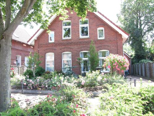 a red brick house with flowers in front of it at Ferienwohnung Sabath, 15105 in Leer