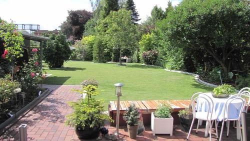 a garden with a table and chairs and a lawn at Ferienwohnung Sabath, 15105 in Leer