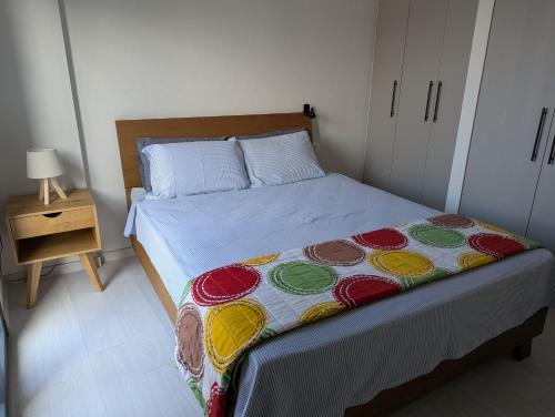 a bedroom with a bed with a colorful blanket on it at kipaki-trachila Mani in Trakhíla