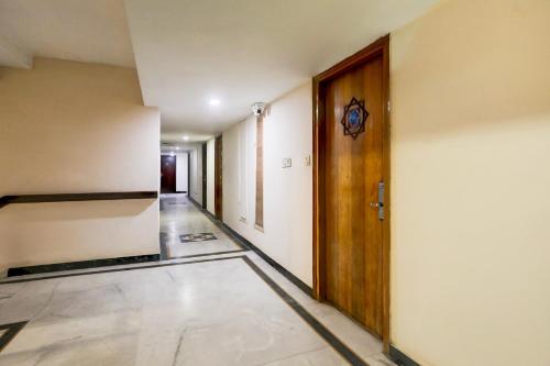 an empty hallway with a wooden door and a hallway at Super Townhouse Padav Square Gwalior Formerly Hotel Shelter in Gwalior