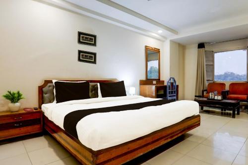 a bedroom with a large bed and a living room at Super Townhouse Padav Square Gwalior Formerly Hotel Shelter in Gwalior