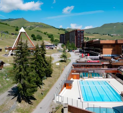 - une vue sur un bâtiment et une piscine dans l'établissement Agréable 28m² - Ski aux pieds, au Corbier