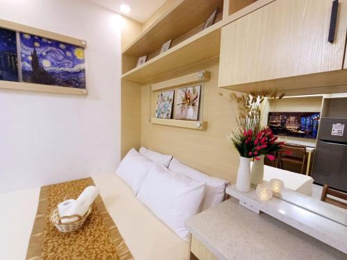 Il comprend un petit salon avec un canapé blanc et une cuisine. dans l'établissement My Staycation moa area S Residences tower1, à Manille