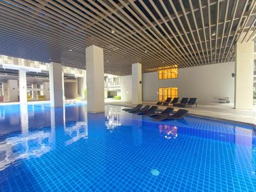une grande piscine avec des chaises dans un bâtiment dans l'établissement My Staycation moa area S Residences tower1, à Manille