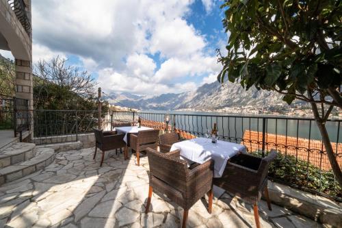 a patio with tables and chairs and a view of the water at Apartments Vuković in Kotor