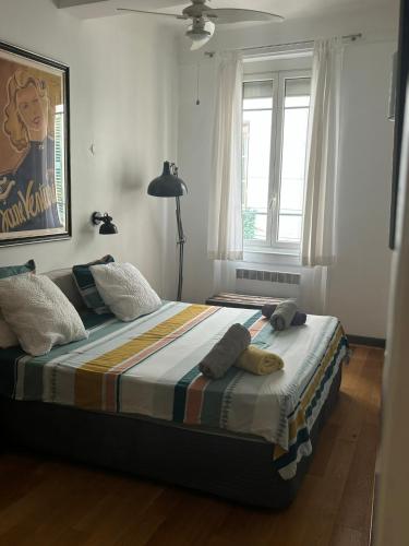 un lit dans une chambre avec une grande fenêtre dans l'établissement 2 bedroom funky apartment in the heart of the old town of Antibes, à Antibes