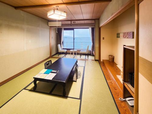 a living room with a table and a view of the ocean at Hotel Cetus Royal in Higashiizu