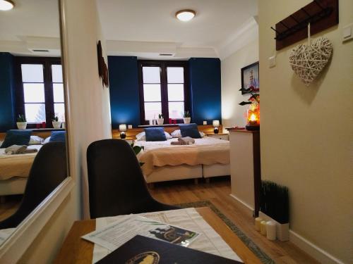 a bedroom with two beds and a table and chairs at Willa Pod Basztą Restauracja&Wellness in Kazimierz Dolny