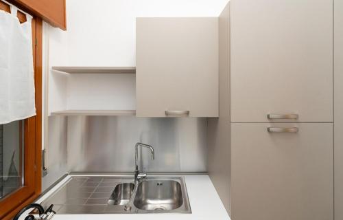 a kitchen with a sink and white cabinets at Mar Beauty Apartment in Chioggia