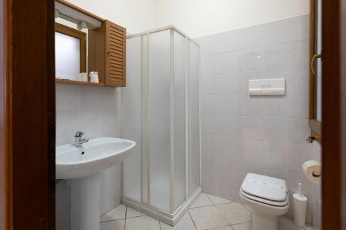 a white bathroom with a sink and a toilet at Mar Beauty Apartment in Chioggia