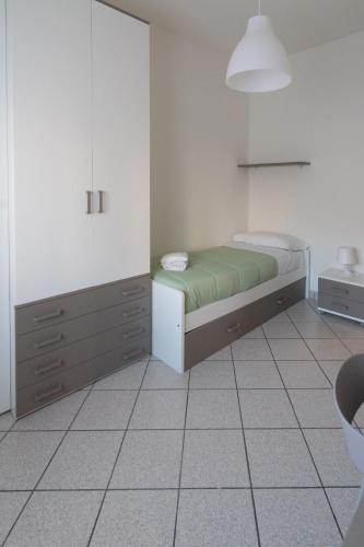 a bedroom with a bed and a cabinet and a tiled floor at Mar Beauty Apartment in Chioggia