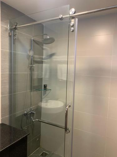 a shower with a glass door in a bathroom at Hoang Long Hotel Phan Thiết in Phan Thiet