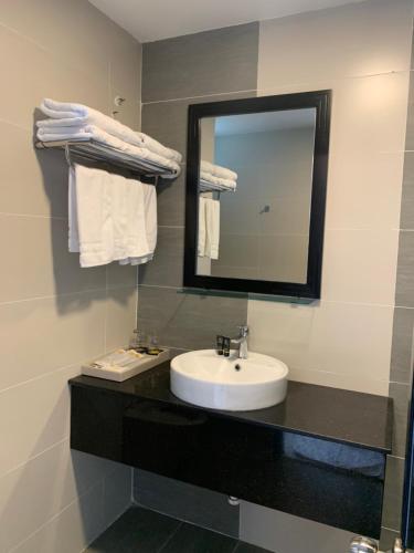 a bathroom with a sink and a mirror at Hoang Long Hotel Phan Thiết in Phan Thiet