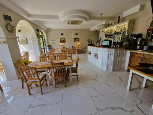 a dining room with tables and chairs and a kitchen at Willa Pod Basztą Restauracja&Wellness in Kazimierz Dolny
