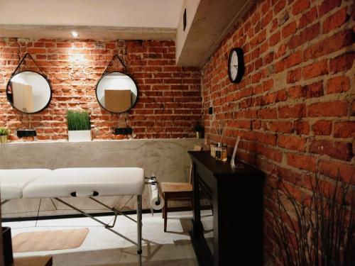 a bathroom with a brick wall and a mirror at Willa Pod Basztą Restauracja&Wellness in Kazimierz Dolny
