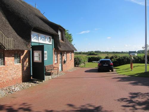 a brick building with a car parked in front of it at Nordseekrabbe 12 Herrenhof in Wrixum
