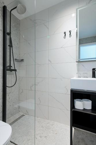 a bathroom with a glass shower stall and a sink at Paviljoni Omorika in Crikvenica