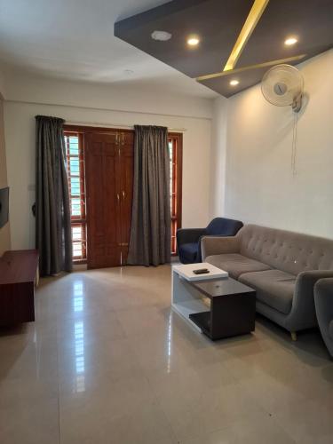 a living room with a couch and a table at Oakhaven Apartments near Mico Layout in Bengaluru