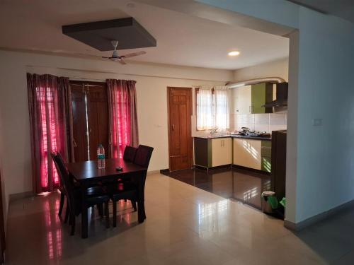 a kitchen and dining room with a table and chairs at Oakhaven Apartments near Mico Layout in Bengaluru