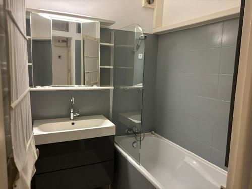 une salle de bain avec un lavabo et une baignoire dans l'établissement 2 bedroom funky apartment in the heart of the old town of Antibes, à Antibes