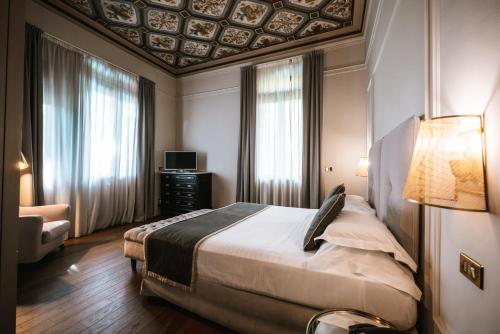 a bedroom with a large bed with a coffered ceiling at Hotel De La Ville in Riccione