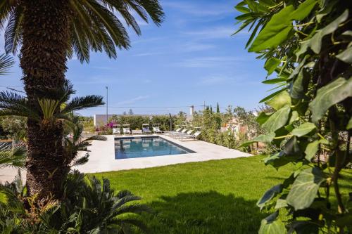 a swimming pool in a yard with a palm tree at Villa Stella in Marsala
