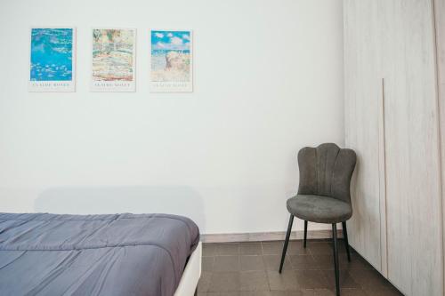 a bedroom with a chair next to a bed at Bigattera Apartments in Varese