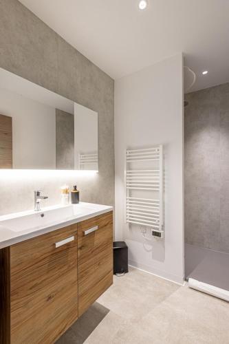 une salle de bain avec un lavabo et une douche dans l'établissement Le Dauphine 3 Allevard, à Allevard