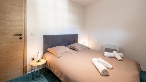 - une chambre avec un grand lit et 2 oreillers blancs dans l'établissement Le Dauphine 3 Allevard, à Allevard