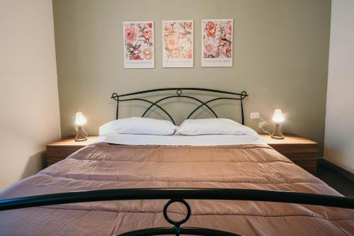 a bedroom with a large bed with two lamps at Bigattera Apartments in Varese
