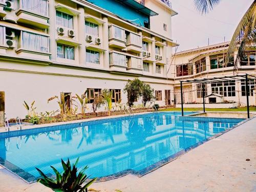 a swimming pool in front of a building at The Regalia Goa in Porvorim