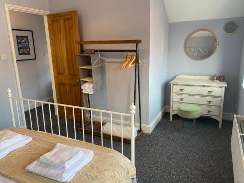 カーディフにあるLovely Coach House with Free Parkingのベッドとドレッサーと鏡のある寝室