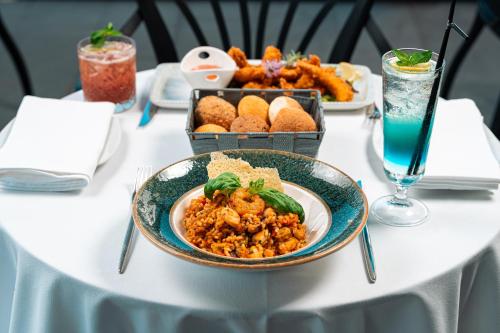 a table with a plate of food and a tray of food at Vivid Blue Serenity Resort in Sveti Stefan