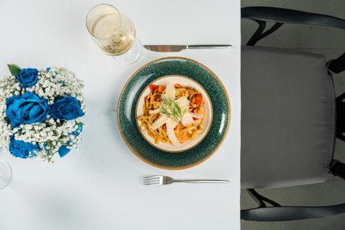 a white table with a bowl of soup and blue roses at Vivid Blue Serenity Resort in Sveti Stefan