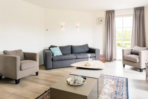 a living room with a couch and chairs and a table at Fazant (12p) in Buren