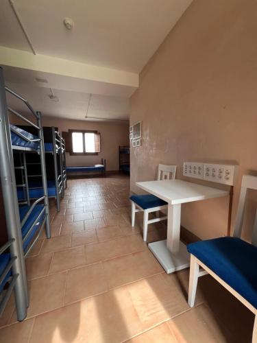 a room with bunk beds and a table and chairs at Ikigai Albergue in Navarrete