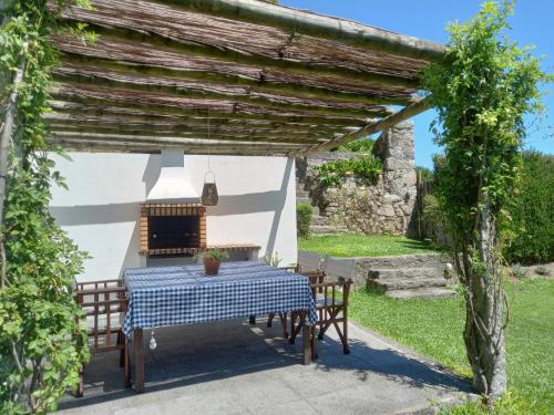 a table and chairs under a pergola in a garden at Coutada dos Pinheiros - Pinheiros Farm House in Fafe