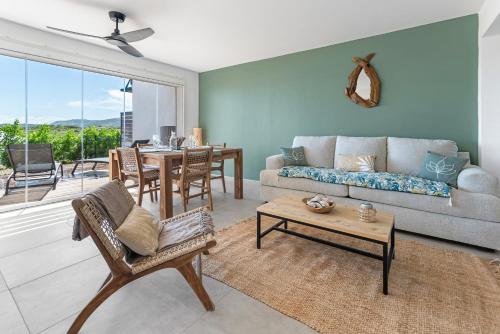 a living room with a couch and a table at Les Griselles 4 sur les hauteurs de la BaieOrientale appart1ch 4p Vue MER in Orient Bay