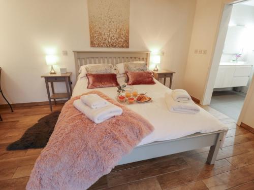 a large bed with towels and drinks on it at The Dairy in Brigg