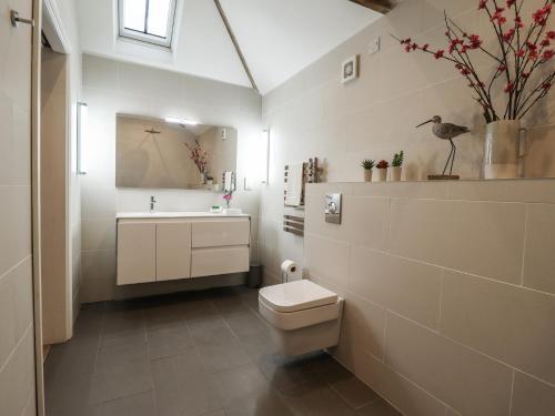 a bathroom with a toilet and a sink at The Dairy in Brigg